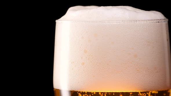 Light Beer Pouring in Glass With Bubbles and Foam