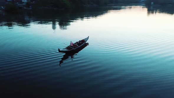 Aerial View of a Luxurious Woman Floating in a Boat on a River at Night