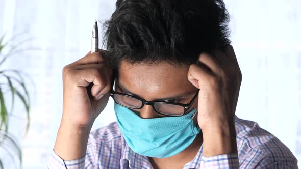 A Young Asian Man with Protective Mask in Face Feeling Sad 