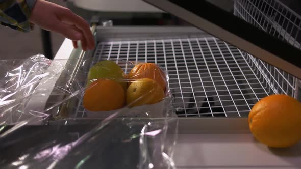 Closeup Female Hands Sealing Fruits in Airtight Plastic Bag