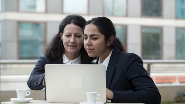 Businesswomen Using Laptop Computer in Cafe