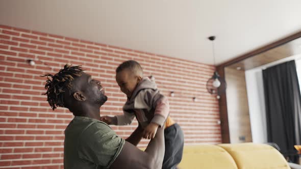 Playful Father Raising His Toddler Son Up in Air Slow Motion