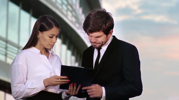 Businesswoman and Businessman Signing Contracts