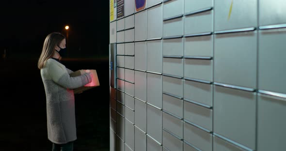 Woman Skans Bar Code in Parcel Locker To Send, Return or Deliver Box at Night