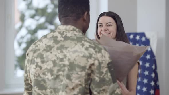 Portrait of Happy Beautiful Woman Receiving Bouquet of Flowers From Man and Hugging Loving Spouse