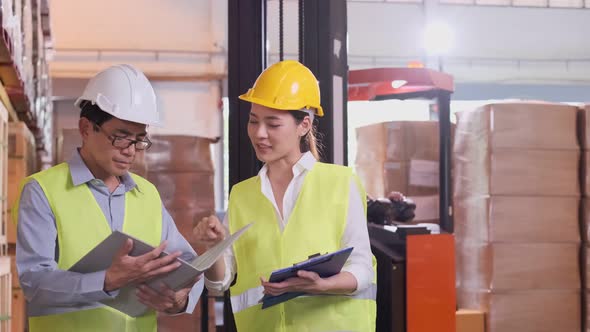 asian Male and Female Industrial Engineers in Hard Hats