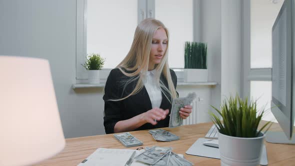 Female Counting Money at Office Workplace. Beautiful Young Blond Woman in Business Suit Sitting in