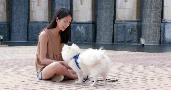 Woman playing with pomeranian dog at outdoot