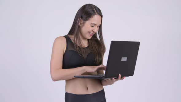 Young Happy Multi-ethnic Woman Using Laptop Ready for Gym