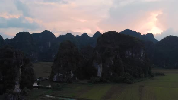 Aerial: North Vietnam karst landscape at sunset, drone view of Ninh Binh region, tourist destination