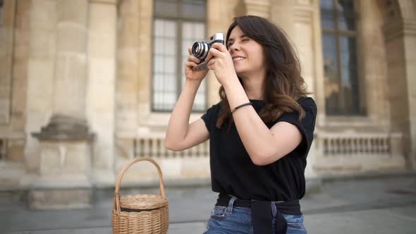 PARIS Pretty Woman Making Photo with a Film Camera on Background