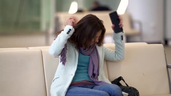 Angry Woman Is Waiting Flight in Airport, Sitting in Waiting Area, Flight Delay or Canceled