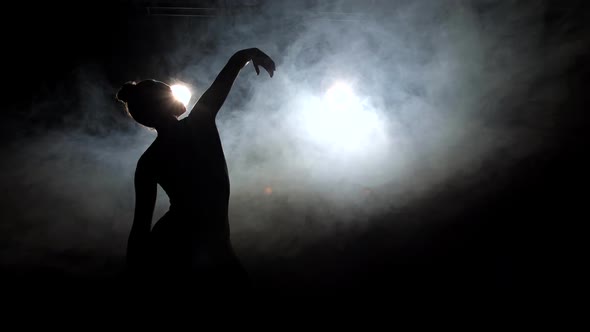 Silhouette of Girl Dancer Raising Hand Up in Dance