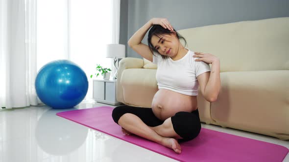 pregnant woman doing yoga exercise in the living room at home