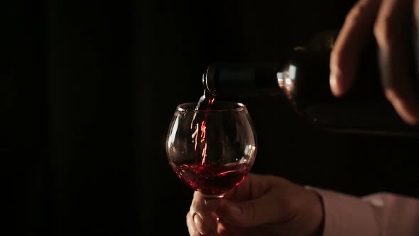 Professional Winemaker Pouring Red Wine Into Glass and Tasting, Close-Up