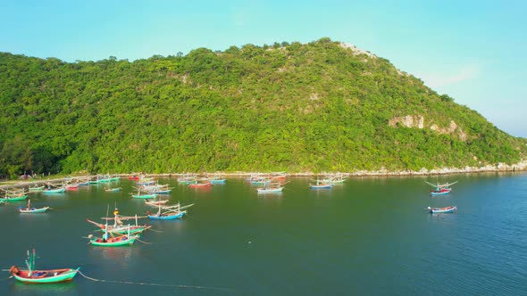 Many fishing boats on the coast beside the mountains, beautiful sea area in Thailand.