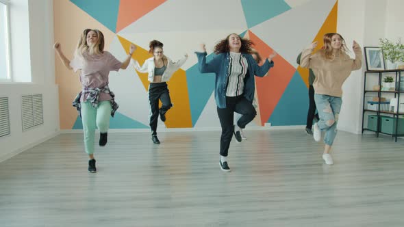 Joyful Girls and Guys Dancing in Dance Studio Learning Contemporary Movements