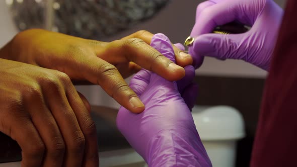 Closeup of Manicure Process and Master Hands Removing Cuticle From Fingernails