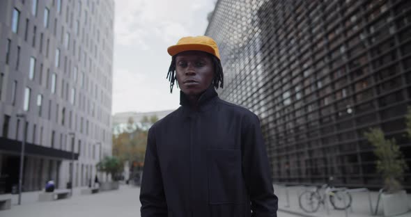 Young African American Man Standing Near the Office Building and Looking at Camera