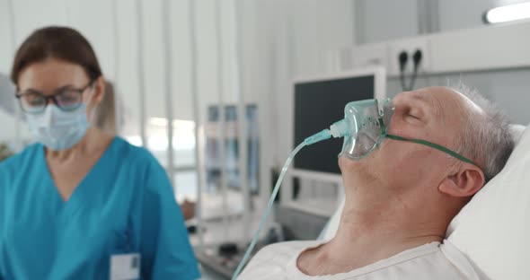 Doctor Checking Senior Man with Oxygen Mask Breathing Hard Because of Infection