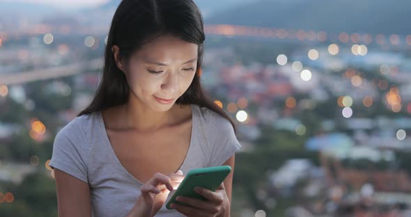 Woman use of mobile phone in the evening 