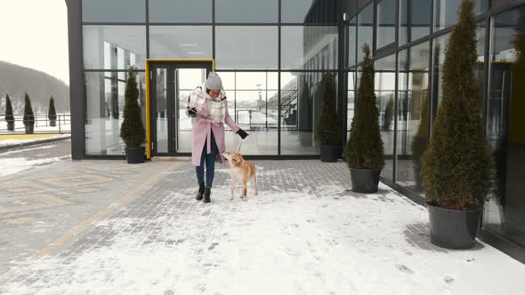 Woman Walking Cute Dog Outdoors on Winter Day