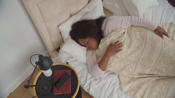 Woman Waking Up with Mobile Alarm Clock in Morning