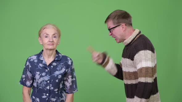 Angry Grandson Talking with Unconcerned Grandmother and Shrugging