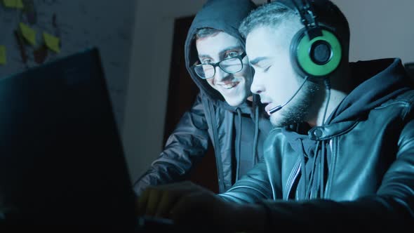 Two Young Hackers Working in Dark Room at Night