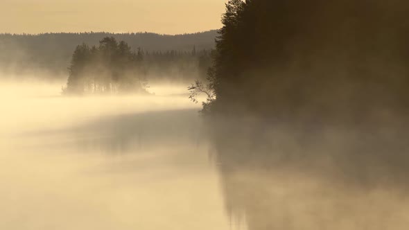 Foggy Morning Lake. Smoke Moving Along Water Surface in Morning Sun Lights. FHD, 