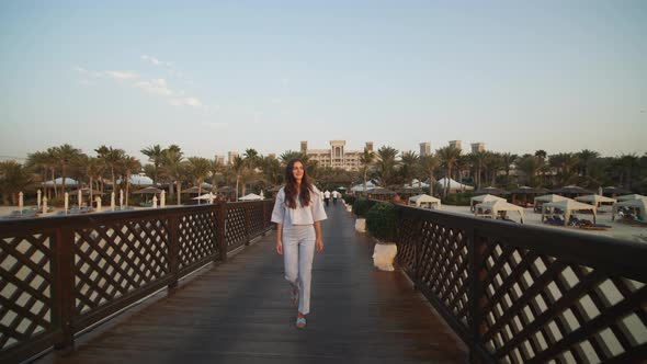 Front View of Woman Walking on Wooden Pier in Luxury Tourist Resort in Dubai