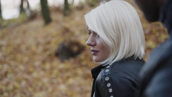 Portrait of Happy Blonde Turns Back and Smiles to Her Man in Park