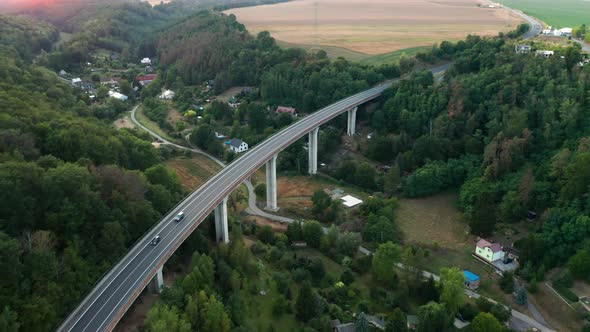 Aerial View of the Bridge with Moving Cars and Amazing Panoramic View of the Forest and Field