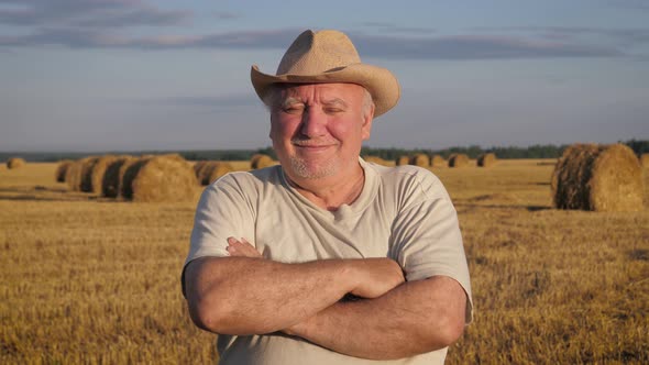 Portrait Man Farmer Stands In Rural Field With His Arms Crossed In Front Of Him