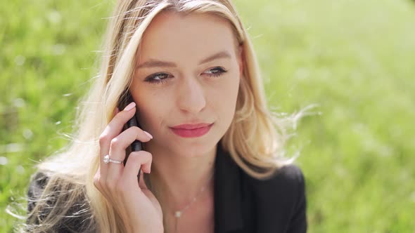 Businesswoman Speaking on Smartphone on Lawn