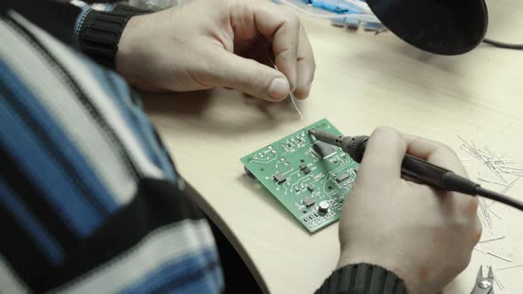 A Worker Is Working on the Creation of an Electronic Board. Close-up.