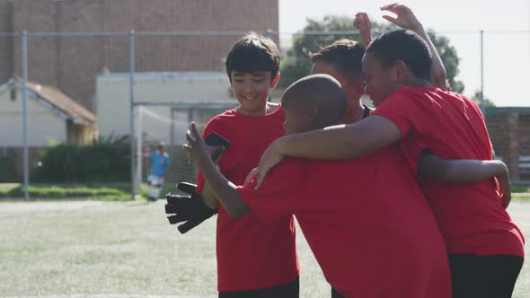 Soccer kids in red taking a selfie and laughing in a sunny day