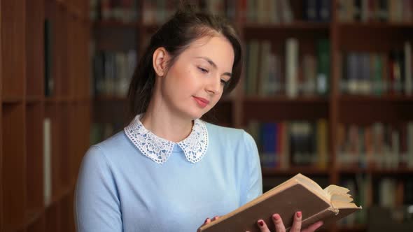 Portrait of Smiling Beautiful Pretty Woman with Book in Library Office Bookshelf Background