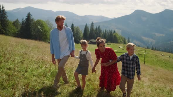 Happy Family Enjoying Walk in Mountains