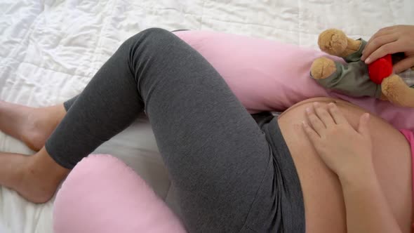 Happy Pregnant Woman Sleeping on Bed in Bedroom