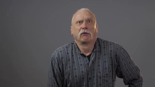 Shocked Elderly Man with Trendy Hairstyle Opens Eyes Widely