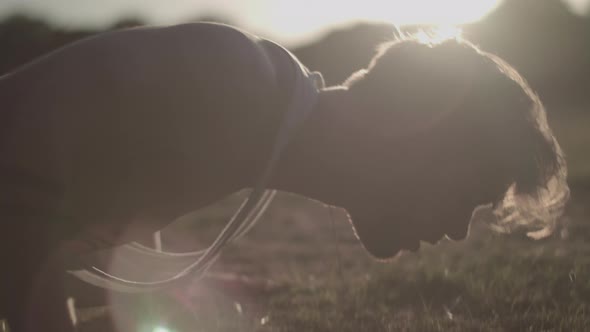 Close Up Shot of Young Attractive Man Doing Push Ups In The Park During Golden Hour - Ungraded