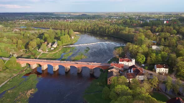 4k Aerial Clip, Flying Over Small City of Kuldiga Latvia, Red Brick Bridge Over River Venta, Wide Wa