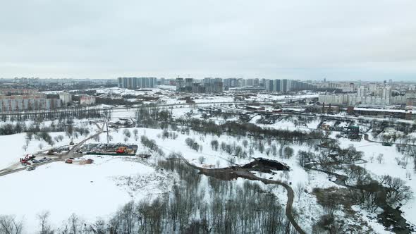 Suburb of a big city. City Park. City highway with busy traffic. Winter cityscape. Aerial photograph