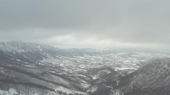 Valley in the Eastern Serbia with mountain Veliki Krs in fog 4K drone video