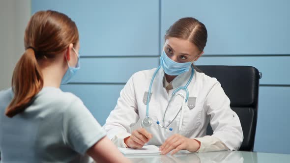 Lady medical consultant in facial mask and white coat