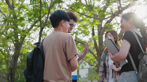 Friendly diverse students talking in park together. Education and student. alt