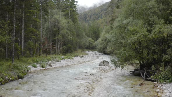 Aerial view of Fast Moving River with Rapids Surrounded by Forest