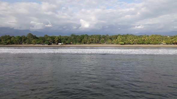 The long and sandy coastline of Quepos beach on Damas Island, Costa Rica. Wide angle aerial tracking