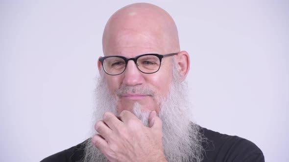 Face of Mature Bald Bearded Man Looking Serious While Thinking